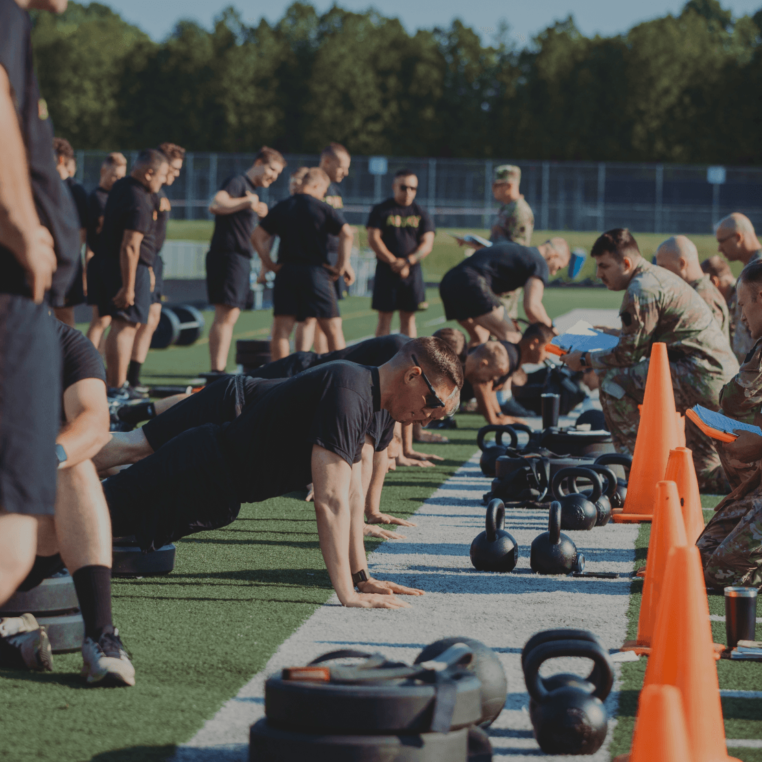 Line of soldiers doing push-ups while graders count